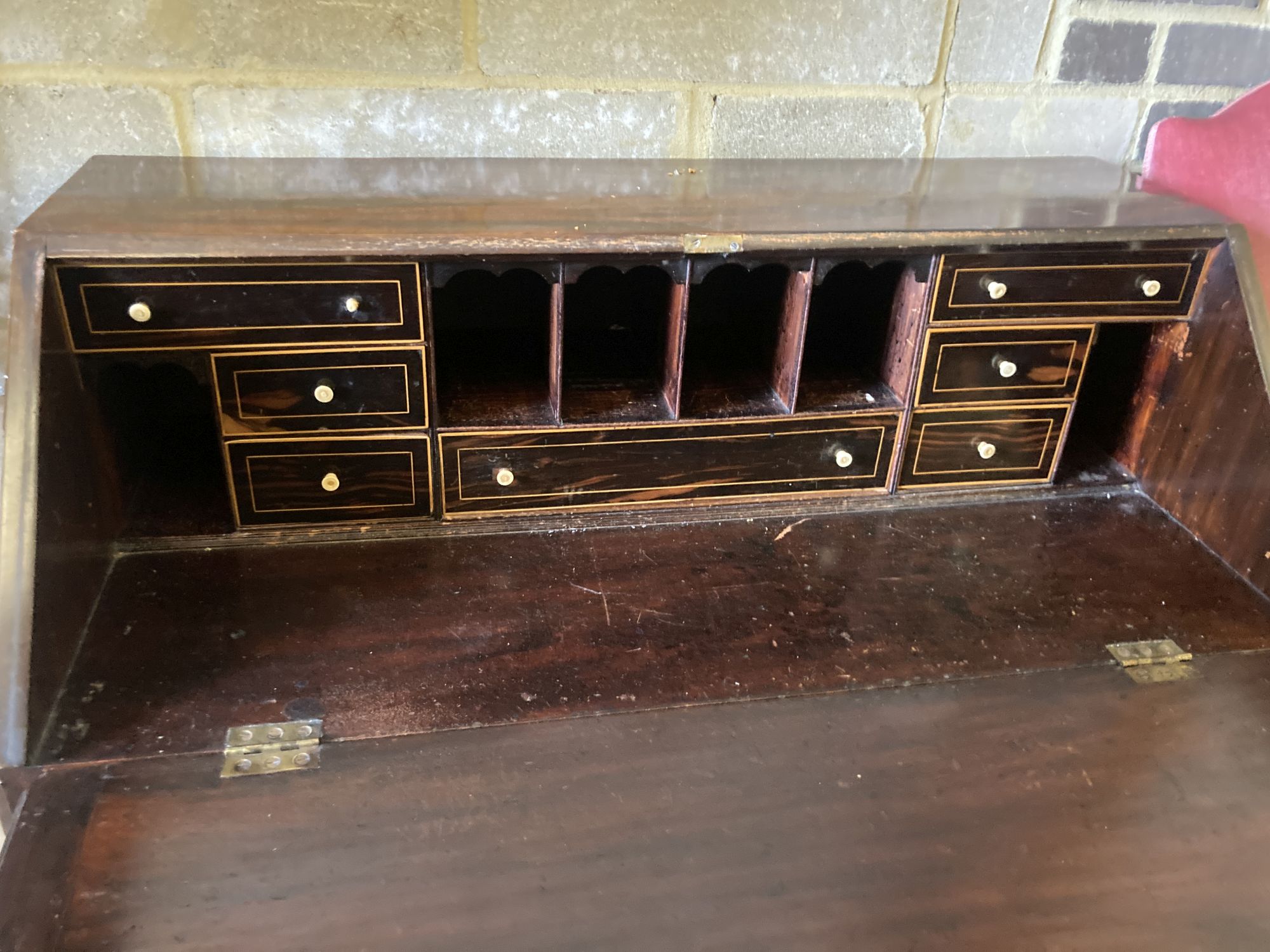 A George III mahogany bureau, the fall enclosing drawers, pigeon holes and secret compartments over four long drawers, width 97cm, dept